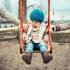 Child on a swing between separated parents
