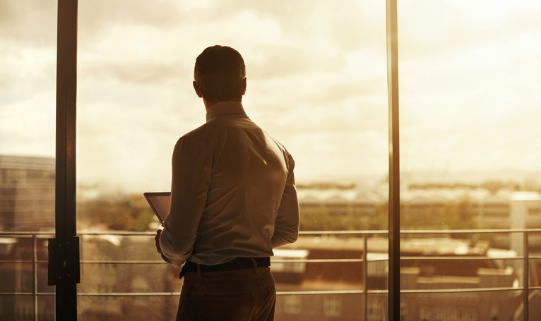 A man looks out over the city horizon.