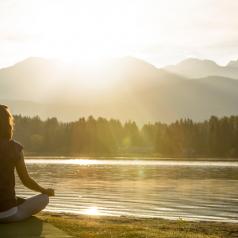 Meditation and yoga practice by lake at sunrise